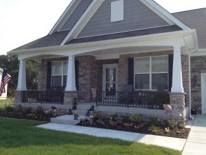 Porch With White Columns With Black Railing